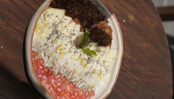 Breakfast bowl with banana, granola, chia seeds and pomegranate