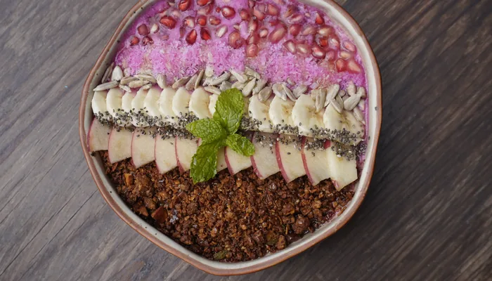 Smoothie bowl with banana, apple, granola and pomegranate